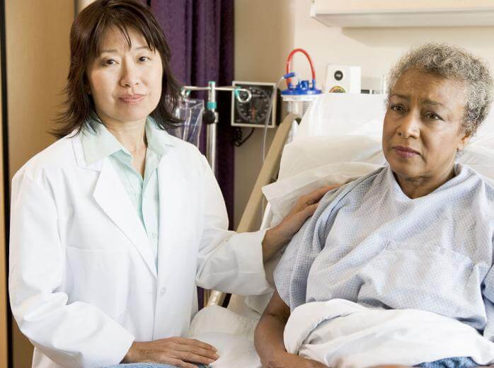 woman in hospital bed with doctor beside her