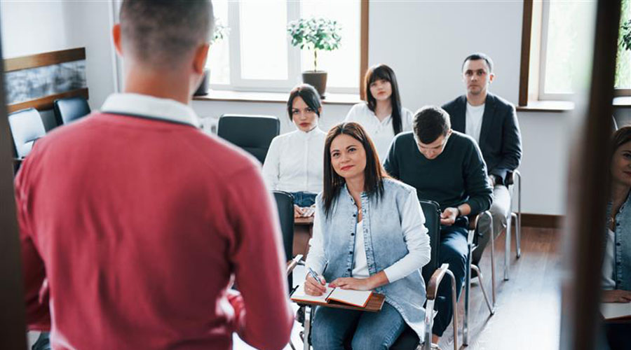 Person in a red shirt standing in front of a class